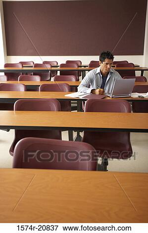Stock Photo - College student sitting in a lecture hall and using a laptop. Fotosearch