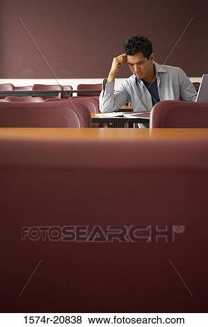 College student sitting in a lecture hall and studying View Large Photo Image Stock Photo - College student sitting in a lecture hall and studying. Fotosearch