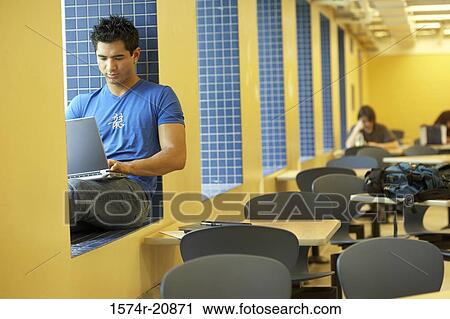 College student sitting on a window ledge and using a laptop View Large Photo Image Stock Image - College student sitting on a window ledge and using a laptop. Fotosearch