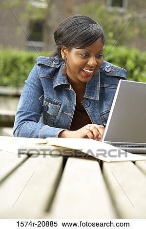 College student using a laptop and smiling View Large Photo Image Stock Photography - College student using a laptop and smiling. Fotosearch