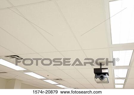 Low angle view of a security camera mounted on a ceiling View Large Photo Image Stock Photo - Low angle view of a security camera mounted on a ceiling. Fotosearch