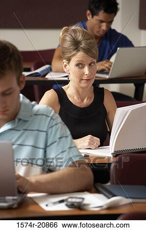 Mid adult woman peeking during an examination View Large Photo Image Stock Photograph - Mid adult woman peeking during an examination. Fotosearch