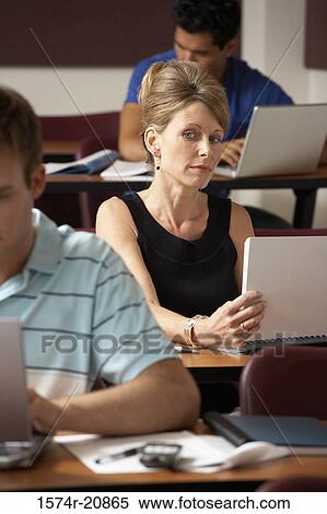 Mid adult woman peeking during an examination View Large Photo Image Stock Photography - Mid adult woman peeking during an examination. Fotosearch