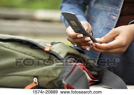Mid section view of a college student using a mobile phone View Large Photo Image Stock Photo - Mid section view of a college student using a mobile phone. Fotosearch