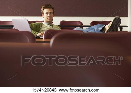 Stock Image - Portrait of a college student sitting in a lecture hall. Fotosearch
