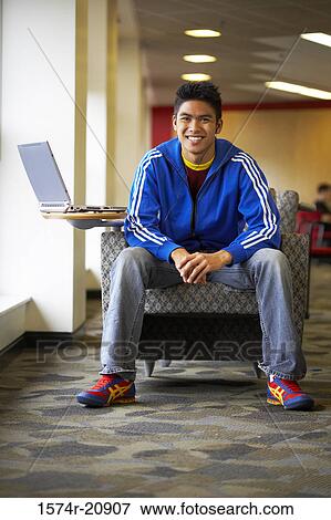 Portrait of a college student sitting in an armchair and smiling View Large Photo Image Stock Photo - Portrait of a college student sitting in an armchair and smiling. Fotosearch