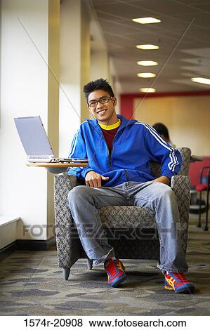 Portrait of a college student sitting in an armchair and smiling View Large Photo Image Stock Photo - Portrait of a college student sitting in an armchair and smiling. Fotosearch