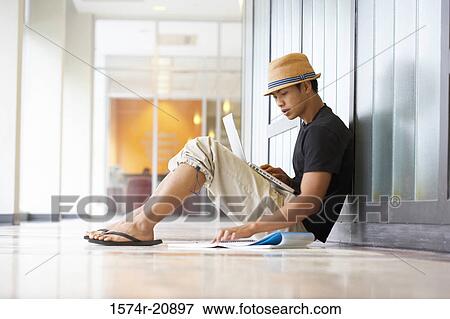 Side profile of a college student sitting in a corridor and reading a book View Large Photo Image Stock Photo - Side profile of a college student sitting in a corridor and reading a book. Fotosearch