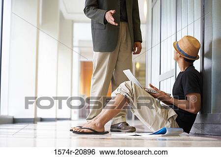 Side profile of a college student sitting in a corridor and looking at a professor View Large Photo Image Stock Photograph - Side profile of a college student sitting in a corridor and looking at a professor. Fotosearch