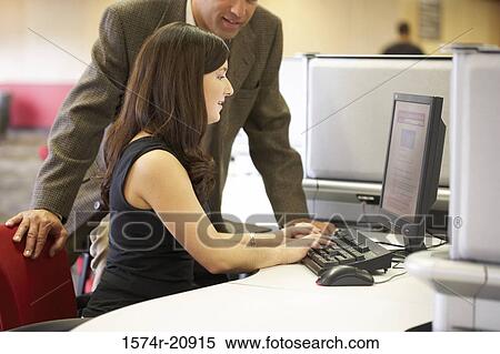 Side profile of a college student working on a computer with her professor standing beside her View Large Photo Image Stock Photography - Side profile of a college student working on a computer with her professor standing beside her. Fotosearch