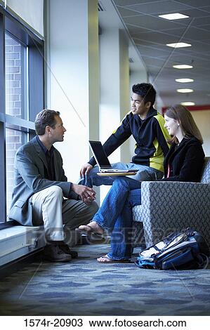 Side profile of a professor talking to his two college students View Large Photo Image Stock Image - Side profile of a professor talking to his two college students. Fotosearch