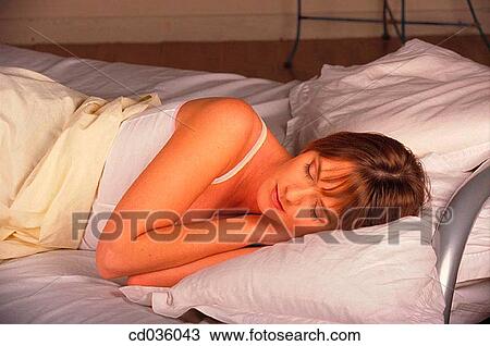 Stock Image - bed, brunette, bedroom, at-home. Fotosearch