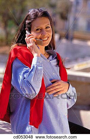 Stock Photo - brunette, calling, cell phone. Fotosearch