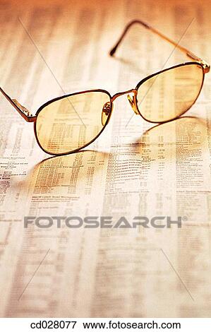 Eyeglasses on stock market report View Large Photo Image Stock Photo - Eyeglasses on stock market report. Fotosearch