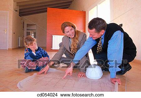 Family looking at blueprint of their new house View Large Photo Image Picture - Family looking at blueprint of their new house. Fotosearch