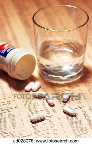 Stock Photo - Headache tablets on stock market report. Fotosearch
