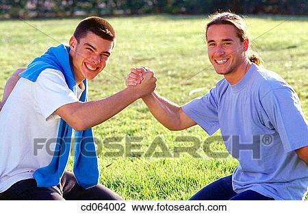 Stock Image - arm wrestling, carefree, boy, black hair, adolescence. Fotosearch