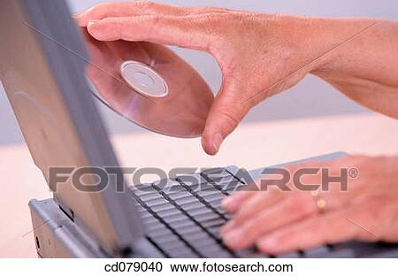 Hands holding CD and laptop View Large Photo Image Stock Image - Hands holding CD and laptop. Fotosearch