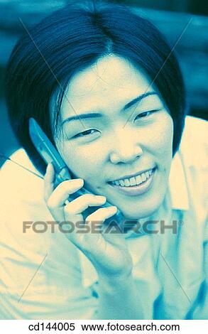 Stock Photography - Asian-American, cell phone, carefree, calling, Asian. Fotosearch
