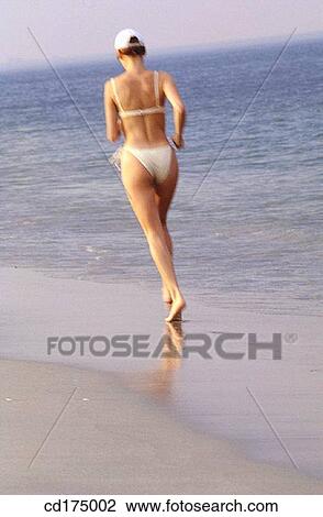 Stock Image - back view, beach, bathing-suit, barefoot, activity. Fotosearch