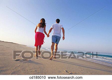 Stock Image - back view, carefree, brunette, beach, activity. Fotosearch