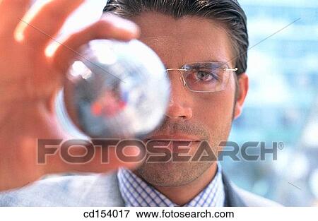 Businessman looking at silver ball View Large Photo Image Stock Photo - Businessman looking at silver ball. Fotosearch