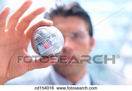 Businessman looking at silver ball View Large Photo Image Stock Photograph - Businessman looking at silver ball. Fotosearch
