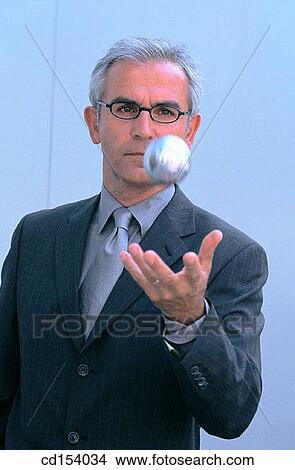 Picture - Businessman throwing silver ball. Fotosearch