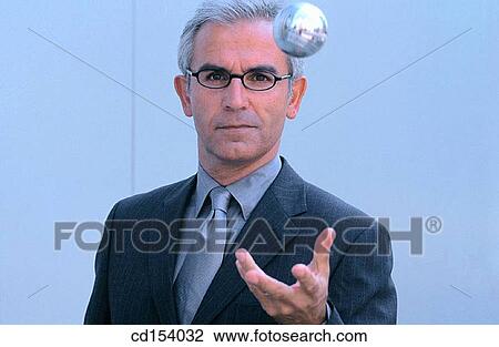 Stock Image - Businessman throwing silver ball. Fotosearch