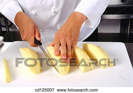 Cheff cutting pineapple View Large Photo Image Stock Photo - Cheff cutting pineapple. Fotosearch