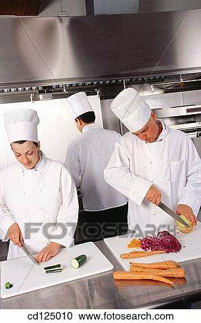 Stock Image - Chefs cuting vegetables. Fotosearch