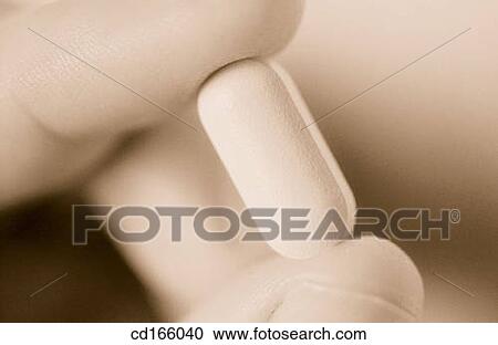 Stock Image - Fingers and pill. Fotosearch