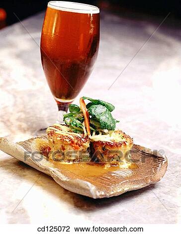 Fish cakes topped with greens and glass of beer View Large Photo Image Stock Image - Fish cakes topped with greens and glass of beer. Fotosearch