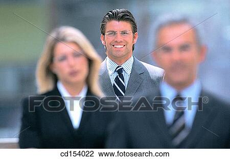 Three businesspeople looking at camera View Large Photo Image Stock Image - Three businesspeople looking at camera. Fotosearch