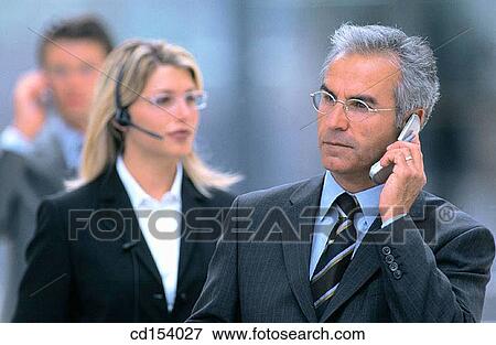 Three businesspeople talking on cell phones View Large Photo Image Stock Photo - Three businesspeople talking on cell phones. Fotosearch