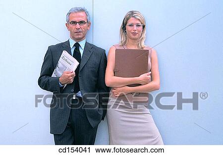 Two businesspeople with files looking at camera View Large Photo Image Stock Image - Two businesspeople with files looking at camera. Fotosearch