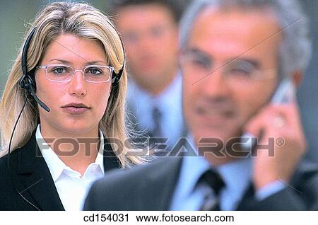 Two executives talking on cell phones, one man standing in the background View Large Photo Image Stock Image - Two executives talking on cell phones, one man standing in the background. Fotosearch