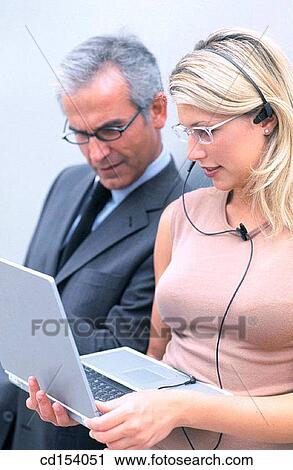 Two executives with laptop and earphone View Large Photo Image Stock Image - Two executives with laptop and earphone. Fotosearch