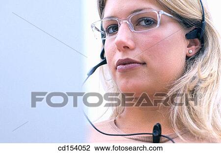 Woman with headset looking at camera View Large Photo Image Stock Image - Woman with headset looking at camera. Fotosearch