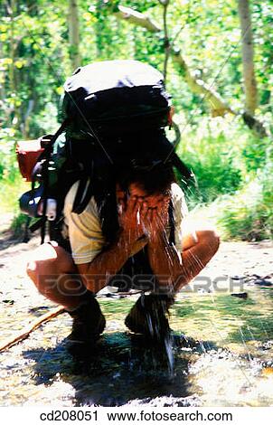 A backpacker washes his face View Large Photo Image Stock Image - A backpacker washes his face. Fotosearch