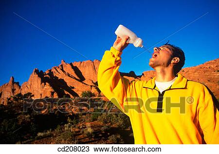 A man squirts water to drink View Large Photo Image Stock Image - A man squirts water to drink. Fotosearch