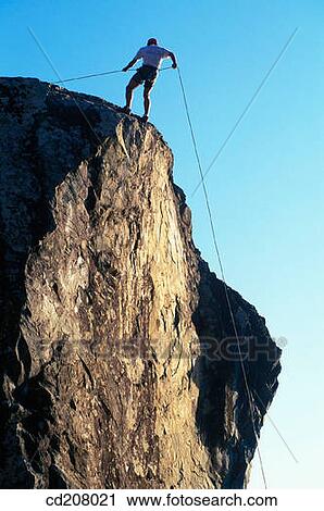 A rock climber rappels down the face of the mountain View Large Photo Image Stock Image - A rock climber rappels down the face of the mountain. Fotosearch