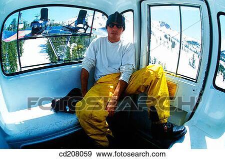A snowboarder riding in a gondola View Large Photo Image Stock Photo - A snowboarder riding in a gondola. Fotosearch