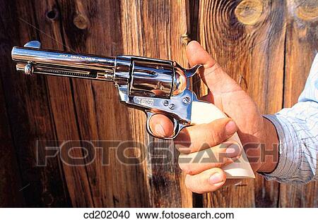 Cowboy's hand holding a collectors colt gun with finger on trigger View Large Photo Image Stock Image - Cowboy's hand holding a collectors colt gun with finger on trigger. Fotosearch