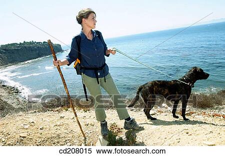 Stock Photography - Detail of a woman and dog, hiking. Fotosearch