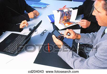 Executives in conference, businessman working with personal organizer View Large Photo Image Stock Image - Executives in conference, businessman working with personal organizer. Fotosearch