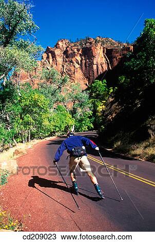 Stock Image - Man goes in-line skating on a mountain road. Fotosearch