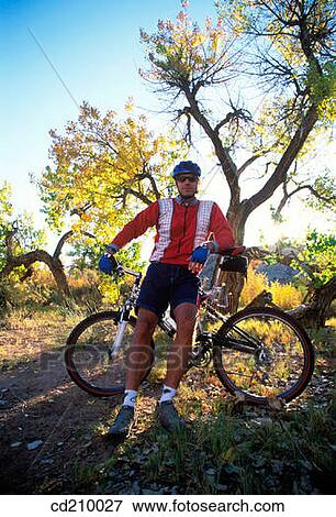 Stock Photo - Man taking a break from mountain biking. Fotosearch