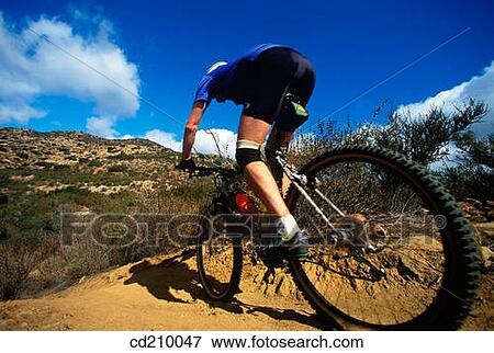 Mountain biker races down hill View Large Photo Image Stock Photo - Mountain biker races down hill. Fotosearch
