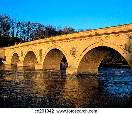 Stock Image - Old stone bridge across river Tweed, Coldstream, Scotland. Fotosearch